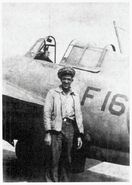 Glenn Poston, ACMM, VF-5’s leading chief, stands next to F-16 (BuNo. 5200) on Guadalcanal, mid-October 1942.