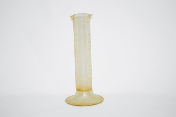 A plastic graduated cylinder damaged by chemicals