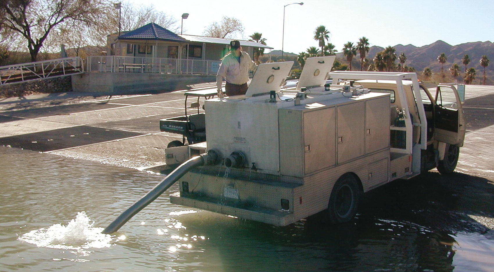 A man on a truck stocking fingerlings into the Colorado River, near Moabi Park, California, USA.