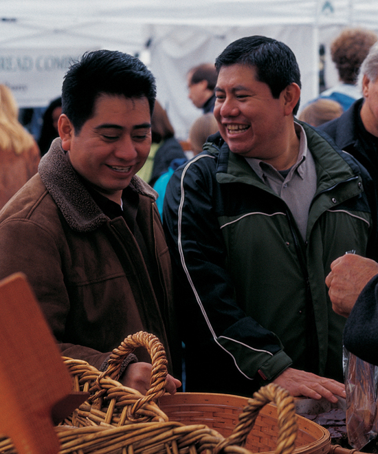 Two men laughing in a market