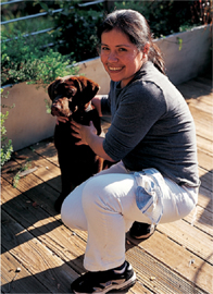 A young woman petting a brown dog