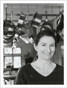 A smiling, handsome woman in a kitchen