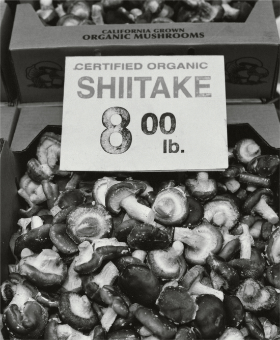 A box of mushrooms with a sign proclaiming Certified Organic Shiitake, eight dollars a pound