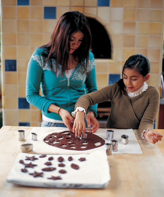 Two young girls cutting out chocolate shapes