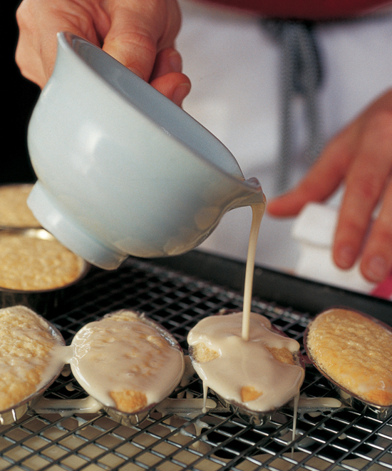 Pouring sauce over the Tres Leches cakes