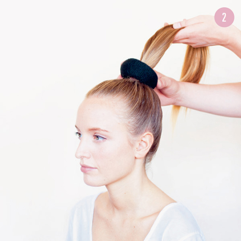 2 Pull the ponytail through the center of the hair donut