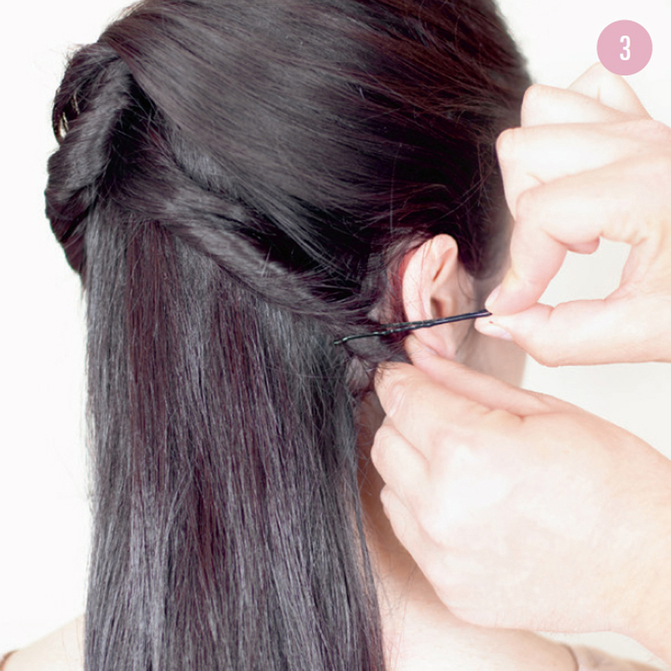 3 Take a good-sized section of hair from one side of the forehead and twirl it back to the opposite side, securing it with a fringe pin. Repeat with all remaining sections of hair at the top, securing underneath to thicken the mass of hair. The idea is to create volume with twirls, which will ultimately be hidden underneath