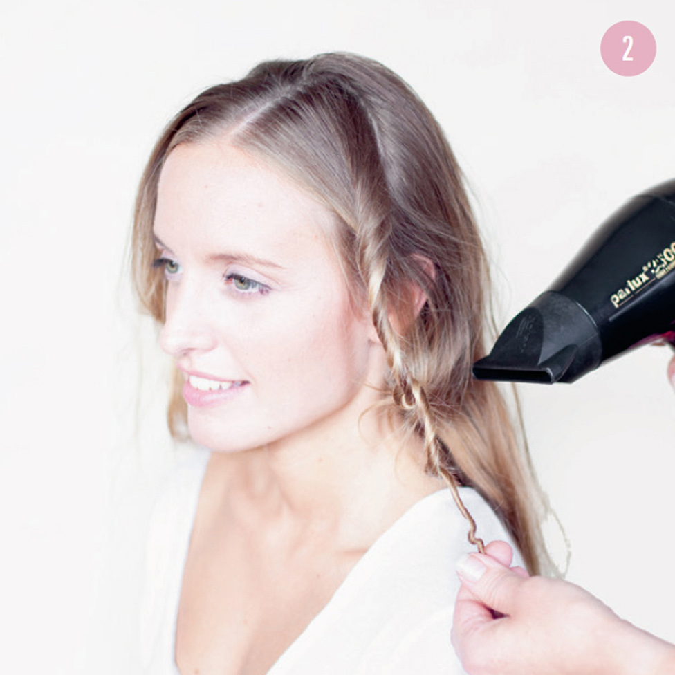 2 Twist a small strand of hair, without extending all the way to the roots, and blow-dry it. Repeat with the rest of your hair