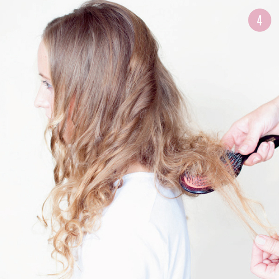 4 Holding the brush in one hand and a section of hair in the other, tease each section, slowly moving up from ends to roots