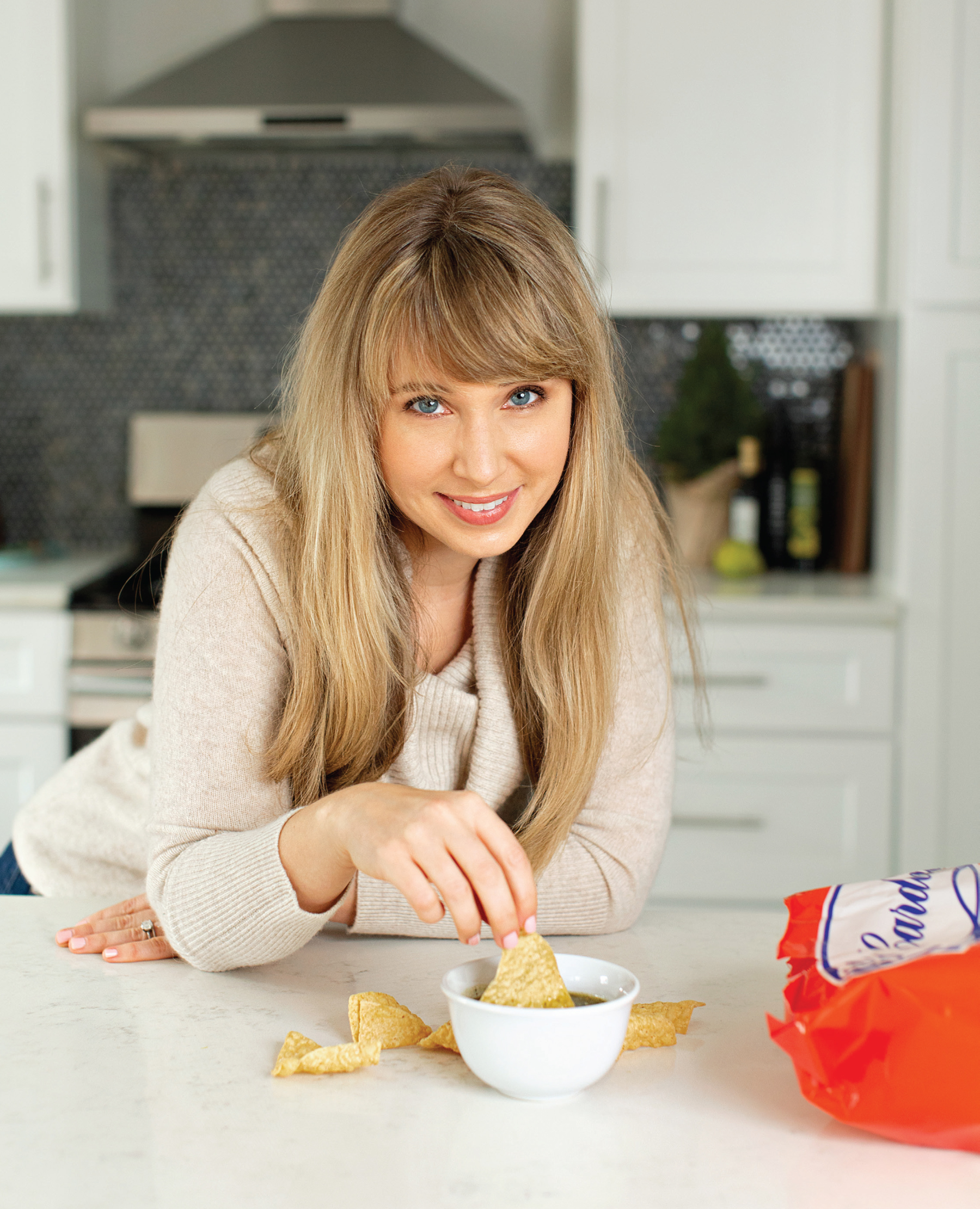 Author Alicia Wolf with bowl of dip and tortilla chips