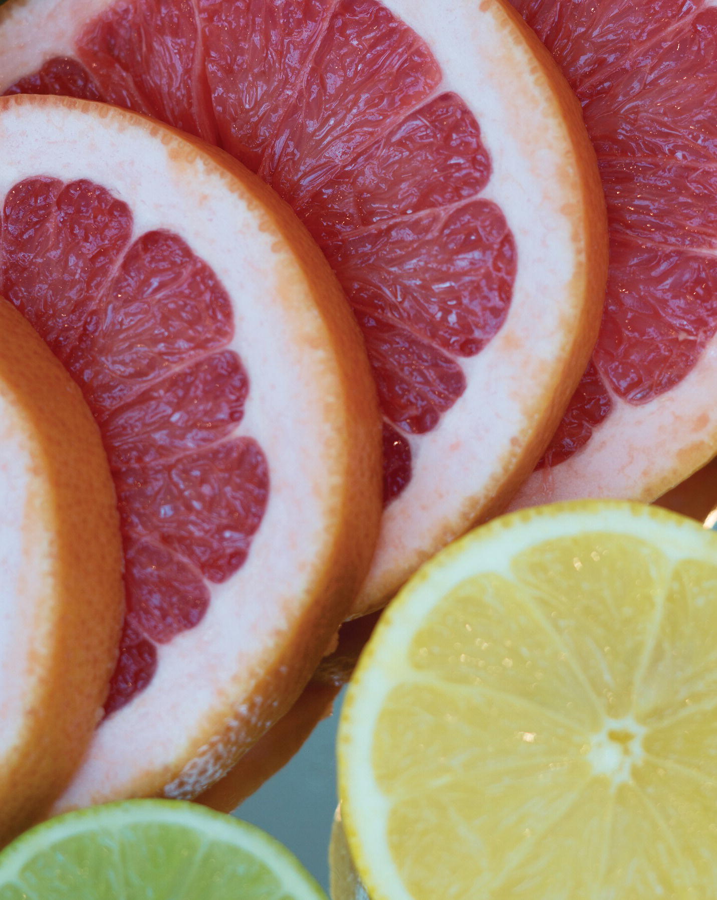 Photo displaying slices of pink grapefruit, lemon, and lime.