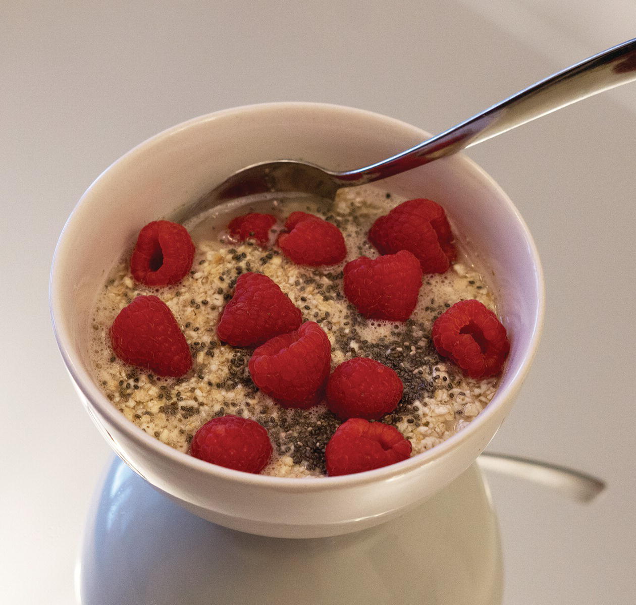 Photo displaying a bowl of oats with chia seeds and raspberries.