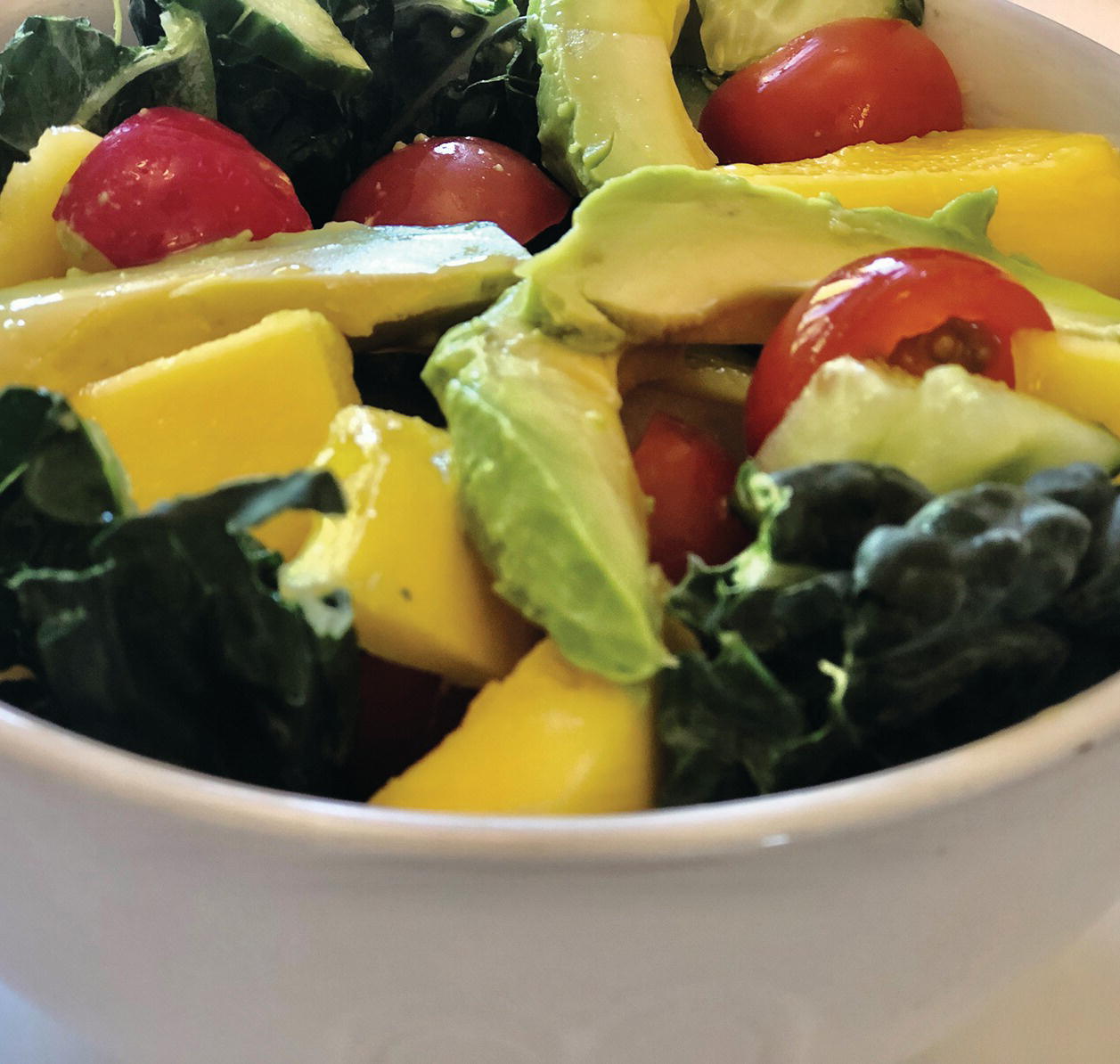 Photo displaying a bowl of kale and mango salad.