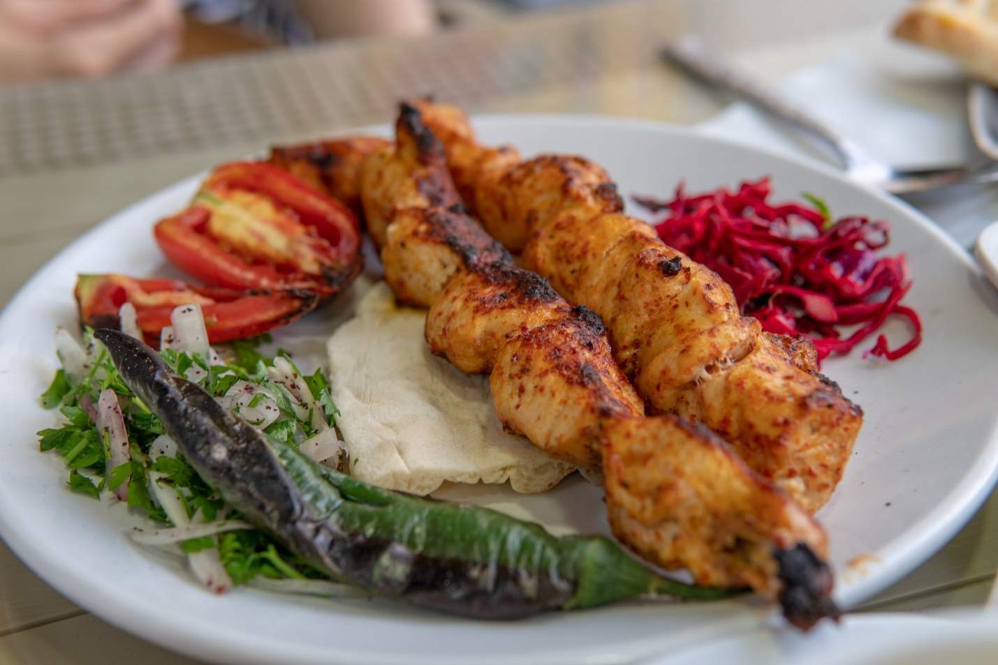 A white plate topped with meat and vegetables Description automatically generated