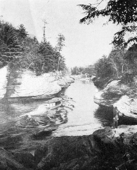 THE NARROWS, DELLS OF THE WISCONSIN One hundred feet deep. The river seems almost to be running on its edge hemmed in by ponderous rocks. Courtesy Wisconsin Geological Survey