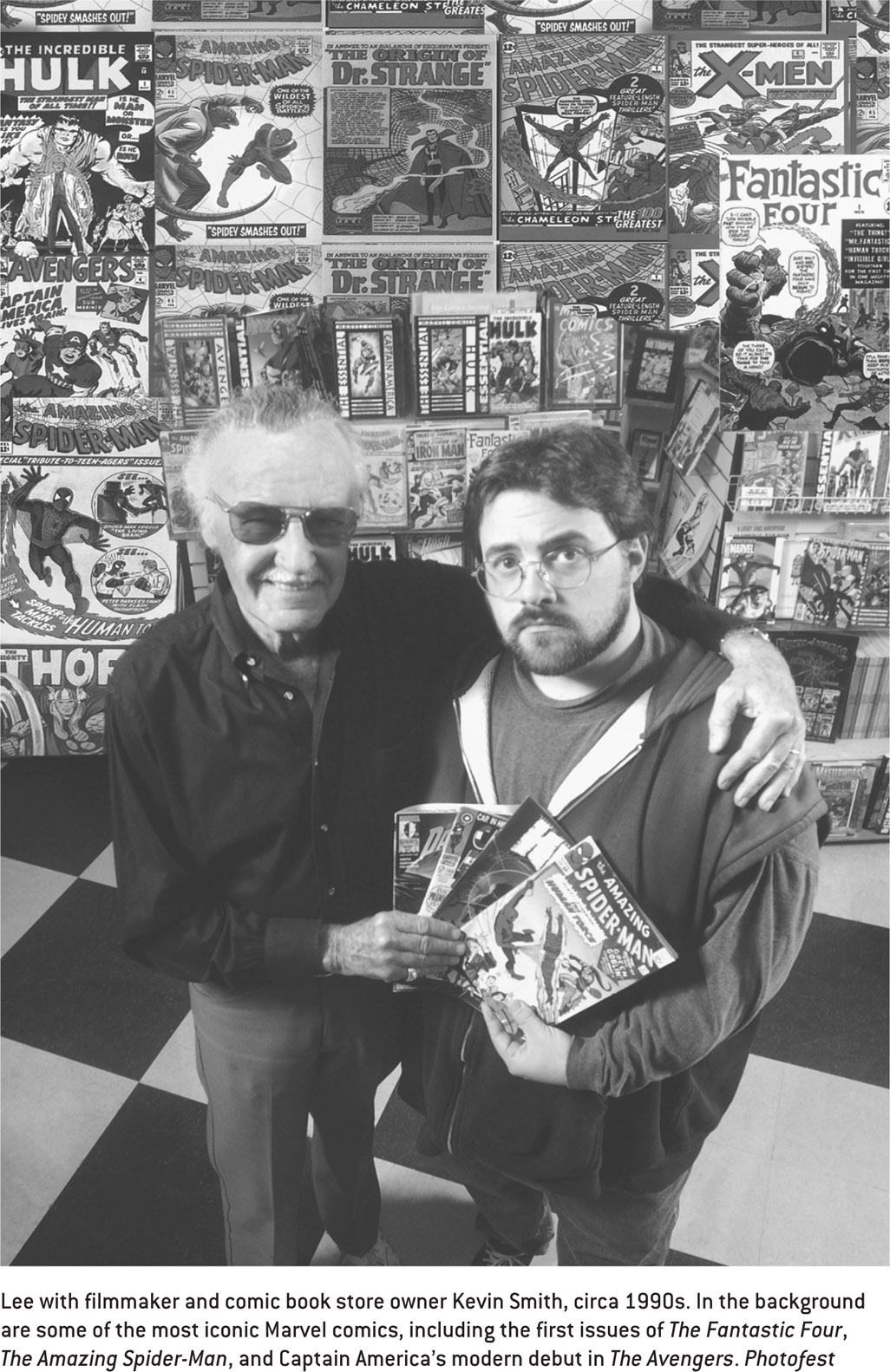 Lee with filmmaker and comic book store owner Kevin Smith, circa 1990s. In the background are some of the most iconic Marvel comics, including the first issues of The Fantastic Four, The Amazing Spider-Man, and Captain America’s modern debut in The Avengers. Photofest