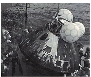 Odyssey, the Apollo 13 command module, is set down by a cable on the USS Iwo Jima in the South Pacific.