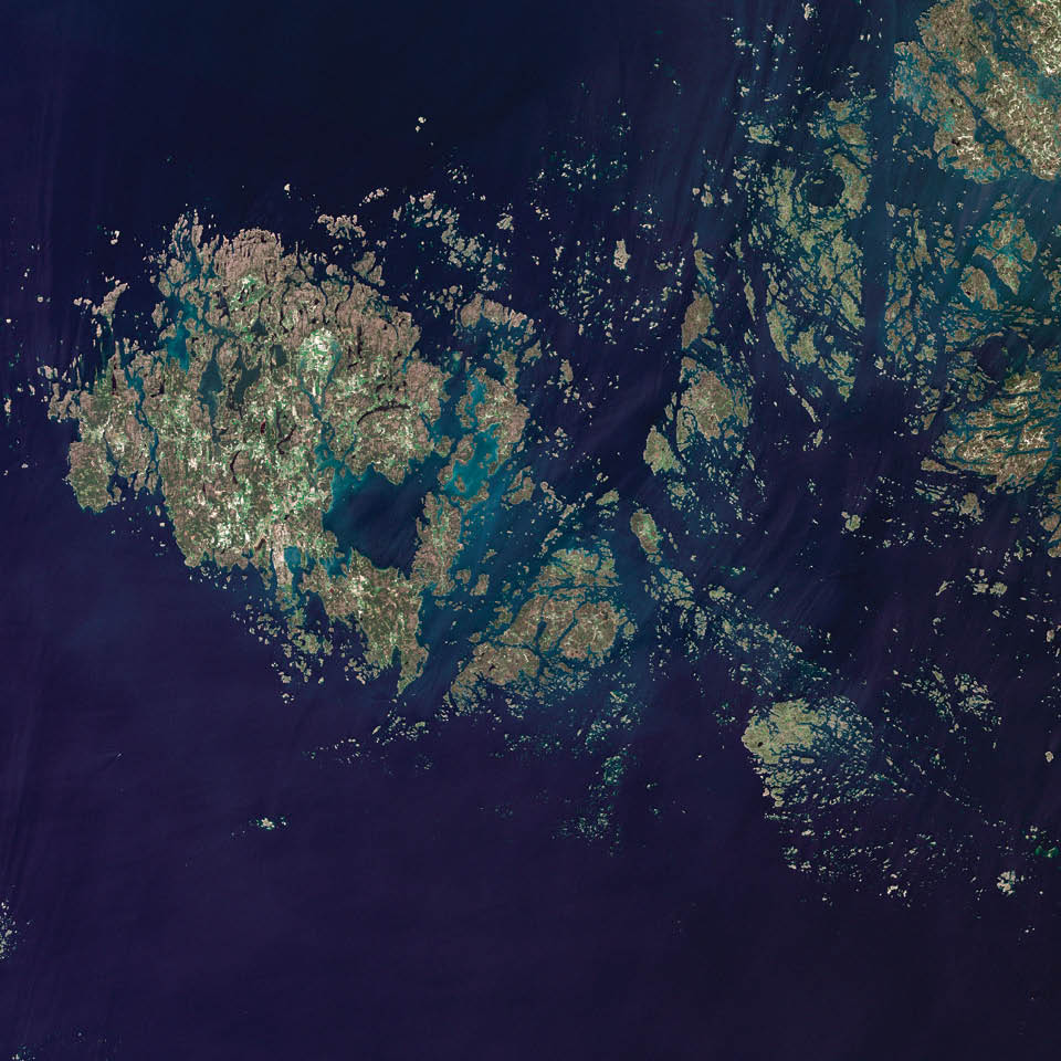 The Åland Islands lie in the Gulf of Bothnia, between Sweden and Finland. The archipelago consists of several large islands and roughly 6,500 small isles, many of them too small for human habitation. They are covered by pine and deciduous forest, meadows, and farmed fields. The region’s characteristic red rapakivi granite also stands out.  Landsat 5 acquired this image in June 2011.