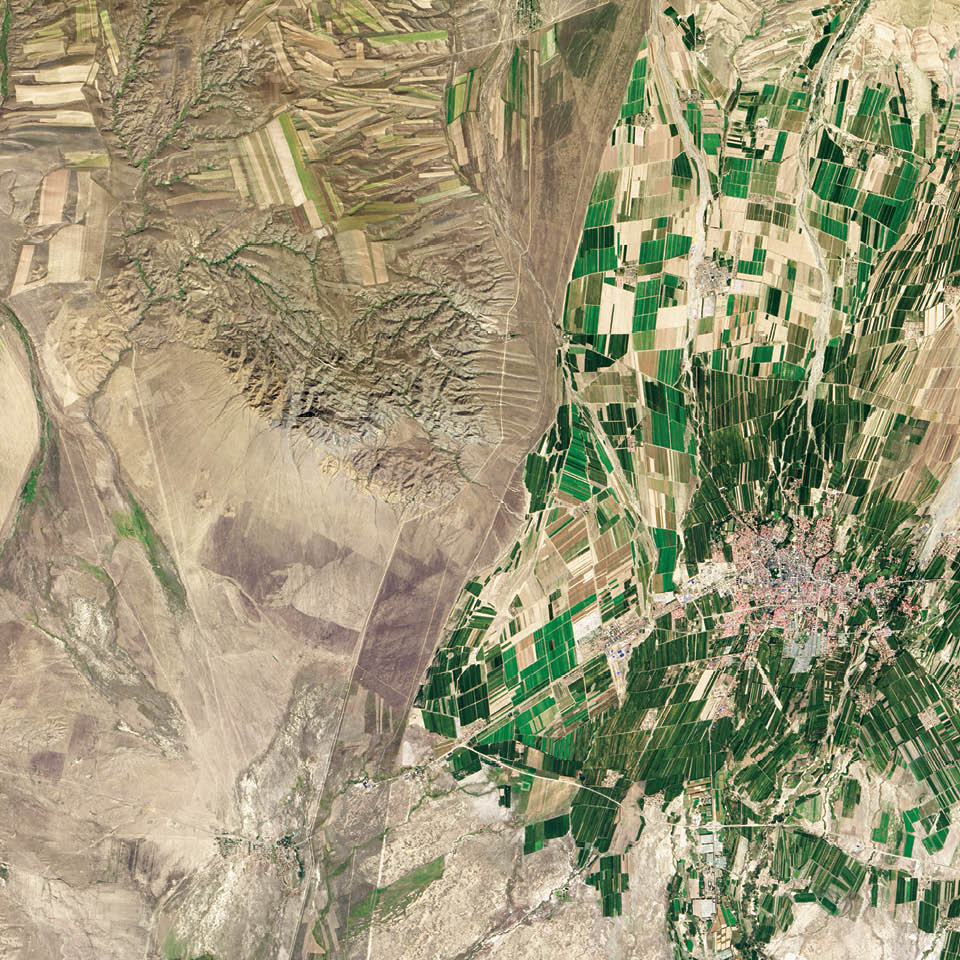 While people often say borders are not visible from space, this line between eastern Kazakhstan and northwestern China could not be clearer. The border is made visible due to land-use policies.  With limited arable land and a large human population to feed, China farms just about any land that can be sustained for agriculture. In this Landsat 8 image from September 2013, fields are dark green in contrast to the surrounding dry landscape, a sign that the farms are irrigated.  While agriculture is important in the Kazakh economy, eastern Kazakhstan is a minor growing area for that country. A few rectangular shapes show that farming does occur. Much of the agriculture on the Kazakh side is rain-fed, so fields are tan like the surrounding, natural landscape.