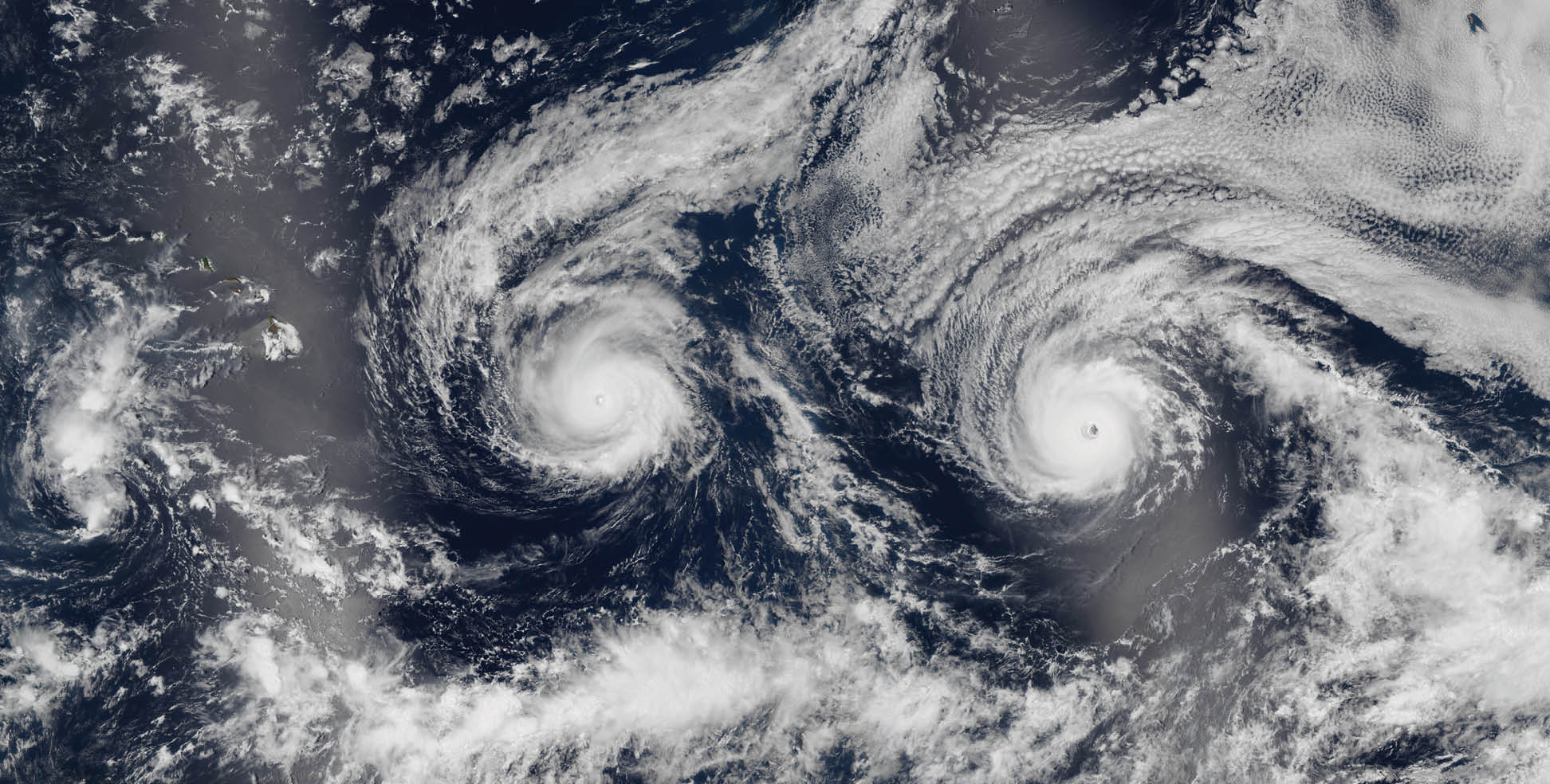 The island of Hawaii rarely takes a direct hit from a hurricane. In August 2016, two Pacific storms almost changed that. The Suomi NPP satellite observed Hurricanes Madeline and Lester stirring up the central Pacific Ocean as category 3 and 4 storms while moving northwest toward the Hawaiian Islands. The tight, deep eye of category 3 Hurricane Madeline (right) appears almost three-dimensional even in a two-dimensional satellite view. Lester (next page) showed off an equally menacing eye. The bright streaks across the ocean surface are areas of sunglint, where sunlight reflected directly back at the image.