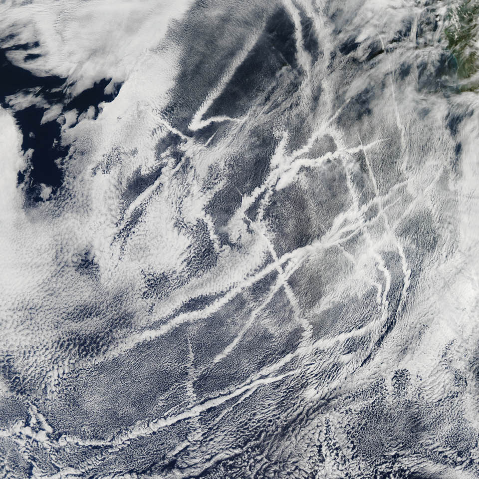 Ships steaming across the Pacific Ocean left this cluster of bright cloud trails lingering in the atmosphere in February 2012. The narrow clouds, known as ship tracks, form when water vapor condenses around tiny particles of pollution from ship exhaust. The crisscrossing clouds off the coast of California stretched for many hundreds of kilometers from end to end. The narrow ends of the clouds are youngest, while the broader, wavier ends are older.