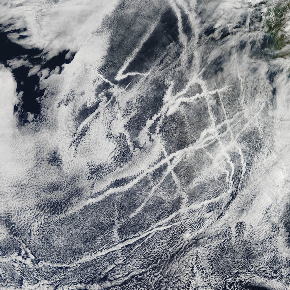 Ships steaming across the Pacific Ocean left this cluster of bright cloud trails lingering in the atmosphere in February 2012. The narrow clouds, known as ship tracks, form when water vapor condenses around tiny particles of pollution from ship exhaust. The crisscrossing clouds off the coast of California stretched for many hundreds of kilometers from end to end. The narrow ends of the clouds are youngest, while the broader, wavier ends are older.