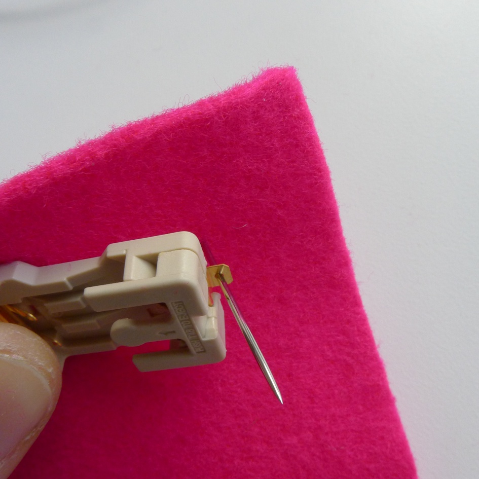 Passing the needle from the back of the fabric through the positive terminal of the LED