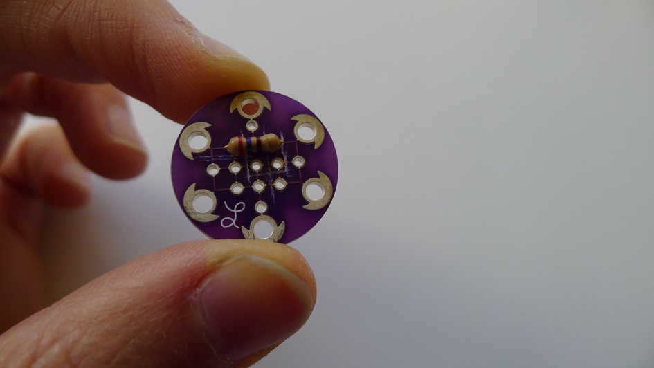 Insert the legs into hole “2” and hole “4,” then pull them through so the resistor sits close to the board