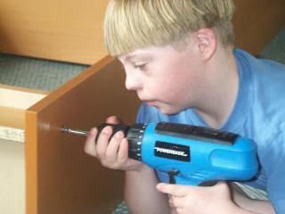 Boy with Down Syndrome assembling a bookcase.