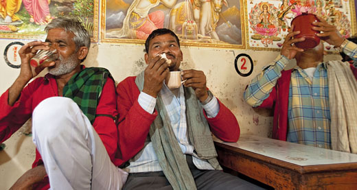 A group of friends drink masala chai at a dhaba, or truck stop, in Delhi, India.