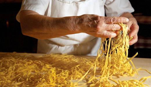 A cook prepares tagliatelle egg noodles at La Vecchia Scuola Bolognese, a cooking school in Bologna, Italy.