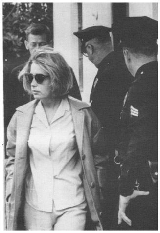 Pat Newcomb and Norman Jeffries (behind her) being escorted out of Marilyns house by two policemen