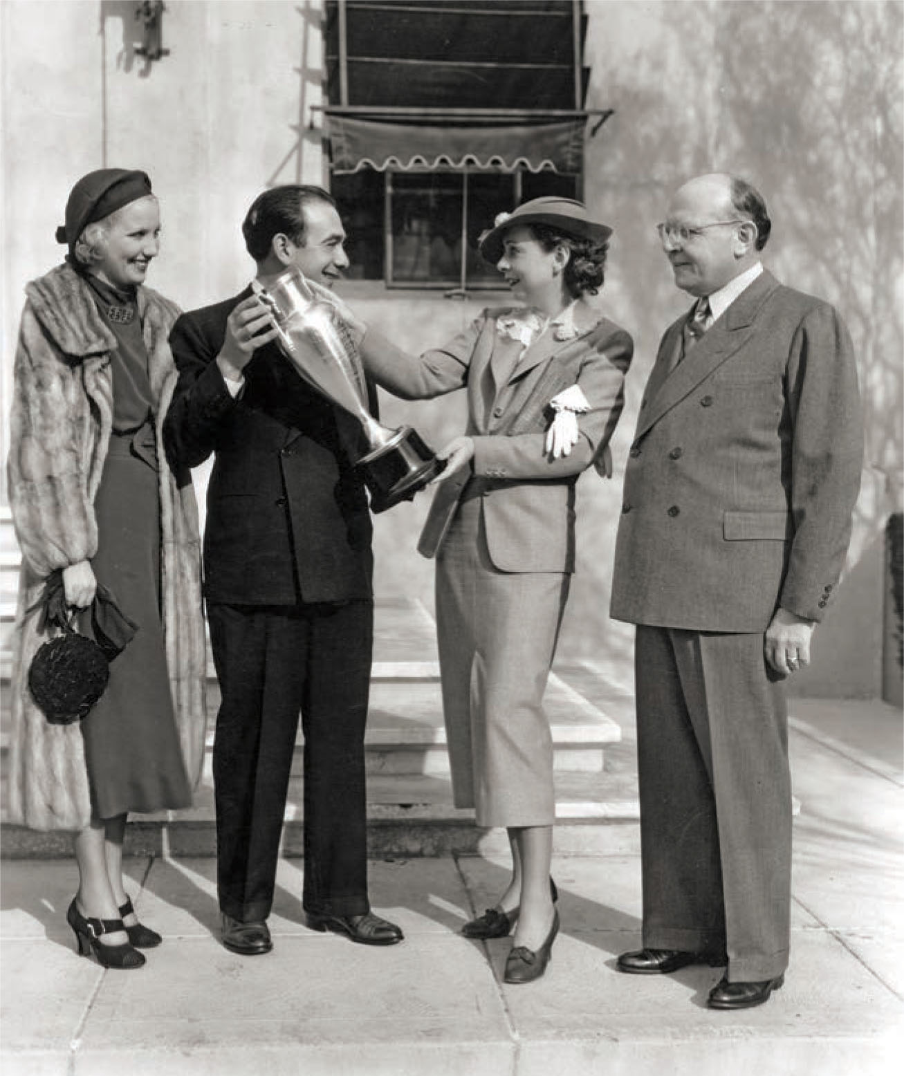 Gwen Wakeling (second from right) receives the silver trophy award given by the Associated Apparel Manufacturers of Los Angeles, 1936.