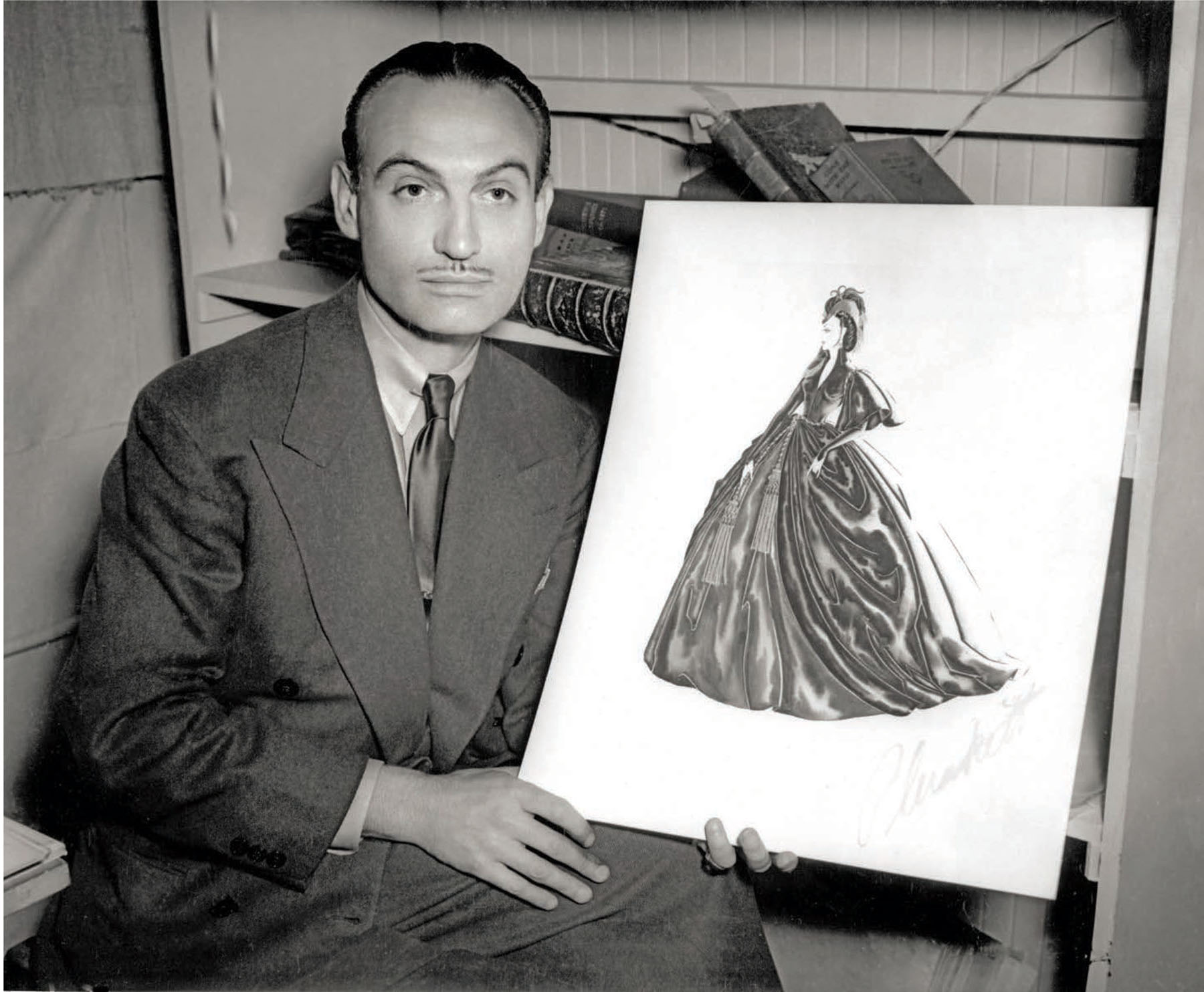 Walter Plunkett with the sketch of the green curtain dress from Gone with the Wind.