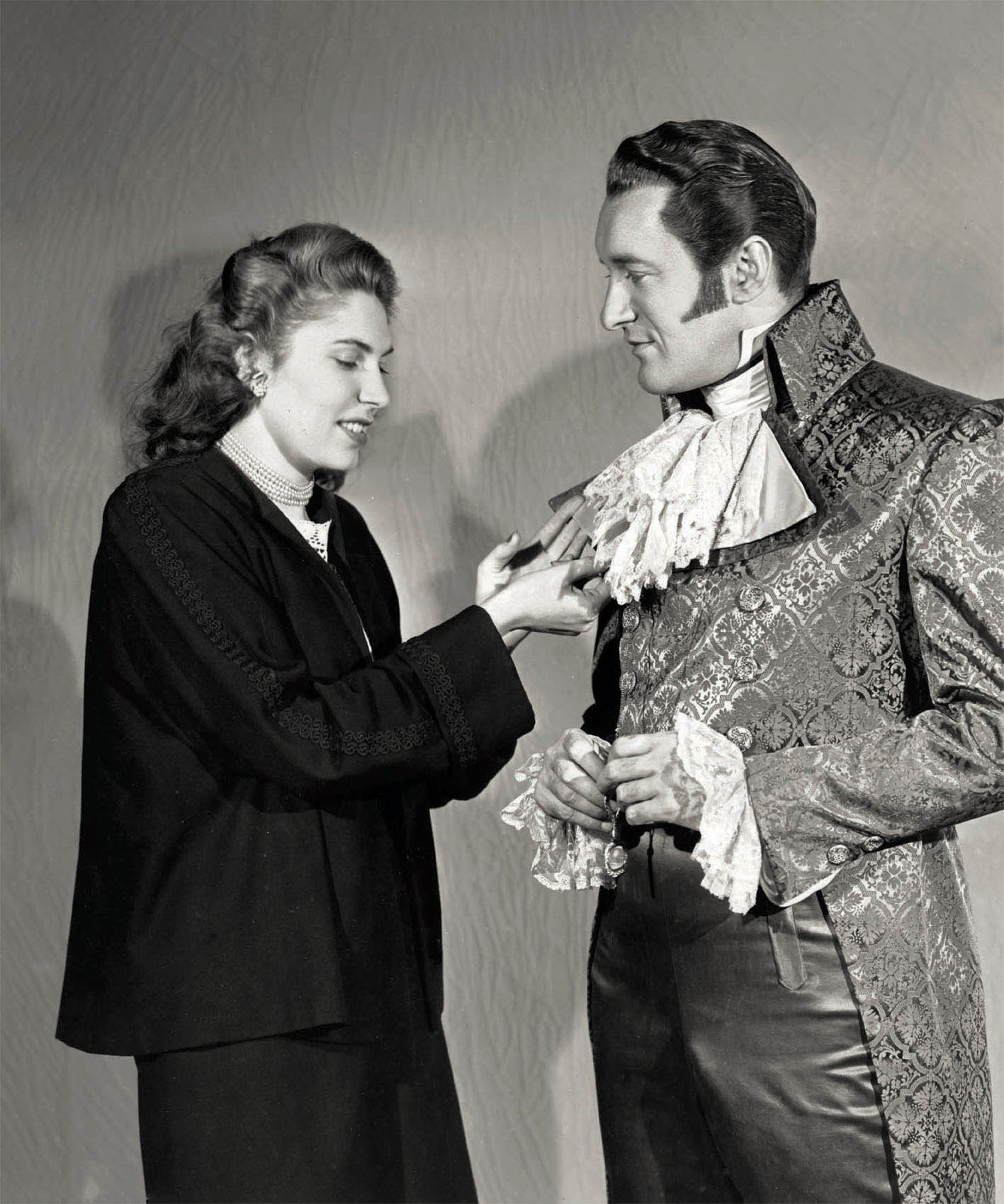 Norma Koch makes an adjustment to George Sanders’s costume in A Scandal in Paris (1946).