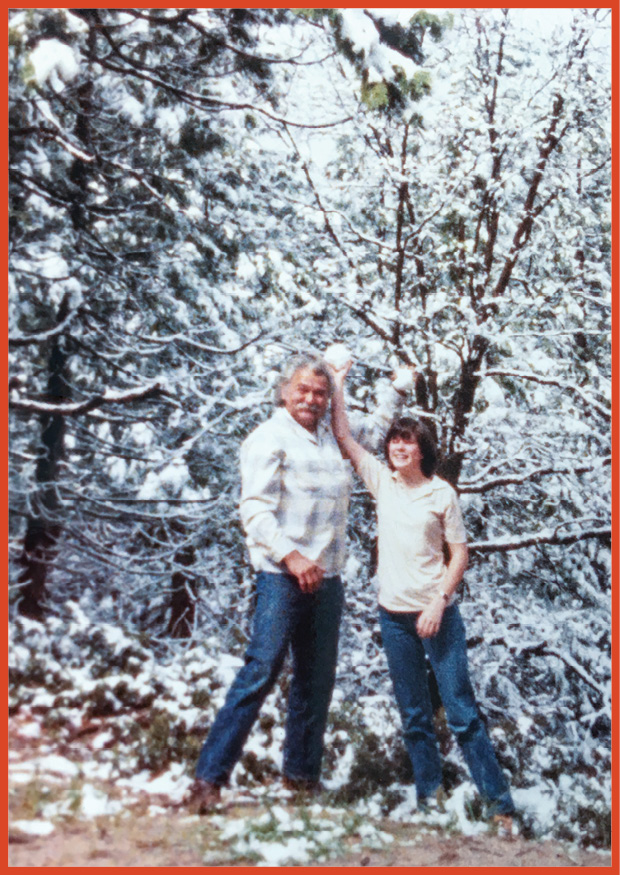 image of grandfather and granddaughter playing in the snow