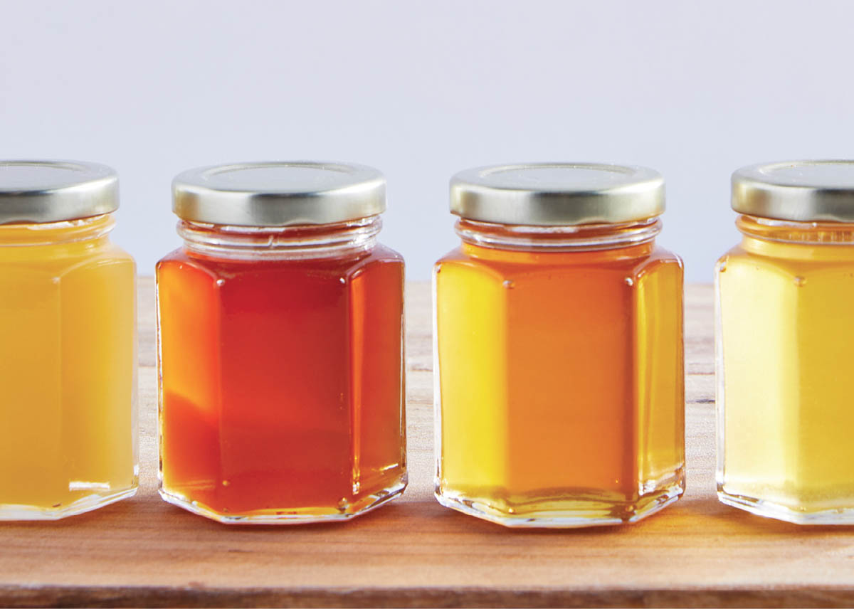 Jars of differently shaded colors of honey.