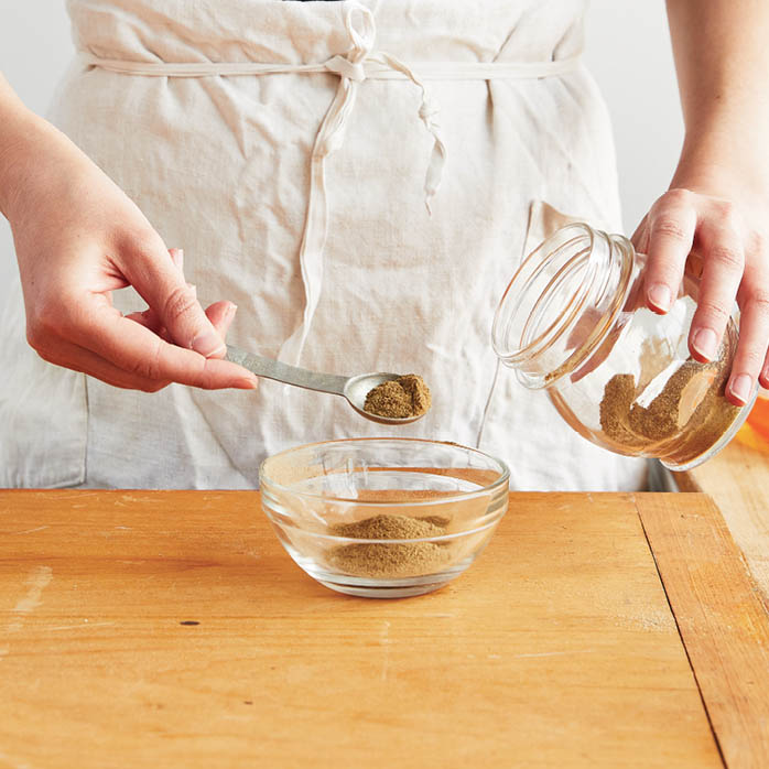 Measuring out teaspoons of powdered formula.