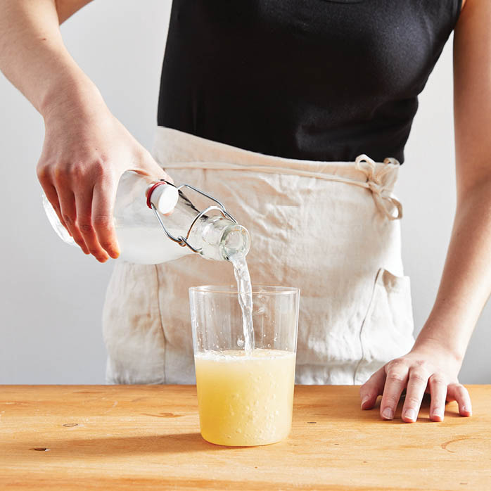 Pouring sparkling water into the jar.