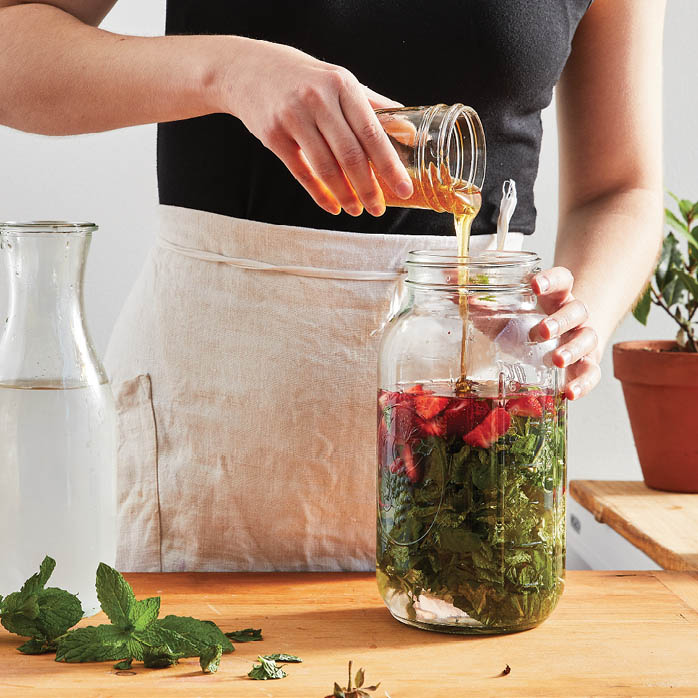 Adding honey to the jar of ingredients.