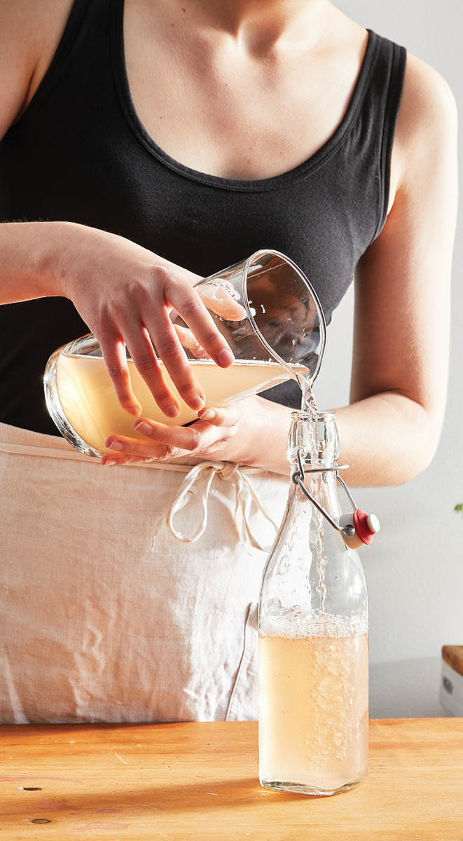 Pouring the soda into a bottle.