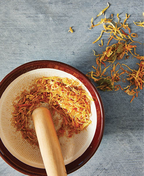 A suribachi mortar and pestle filled with flower petals.