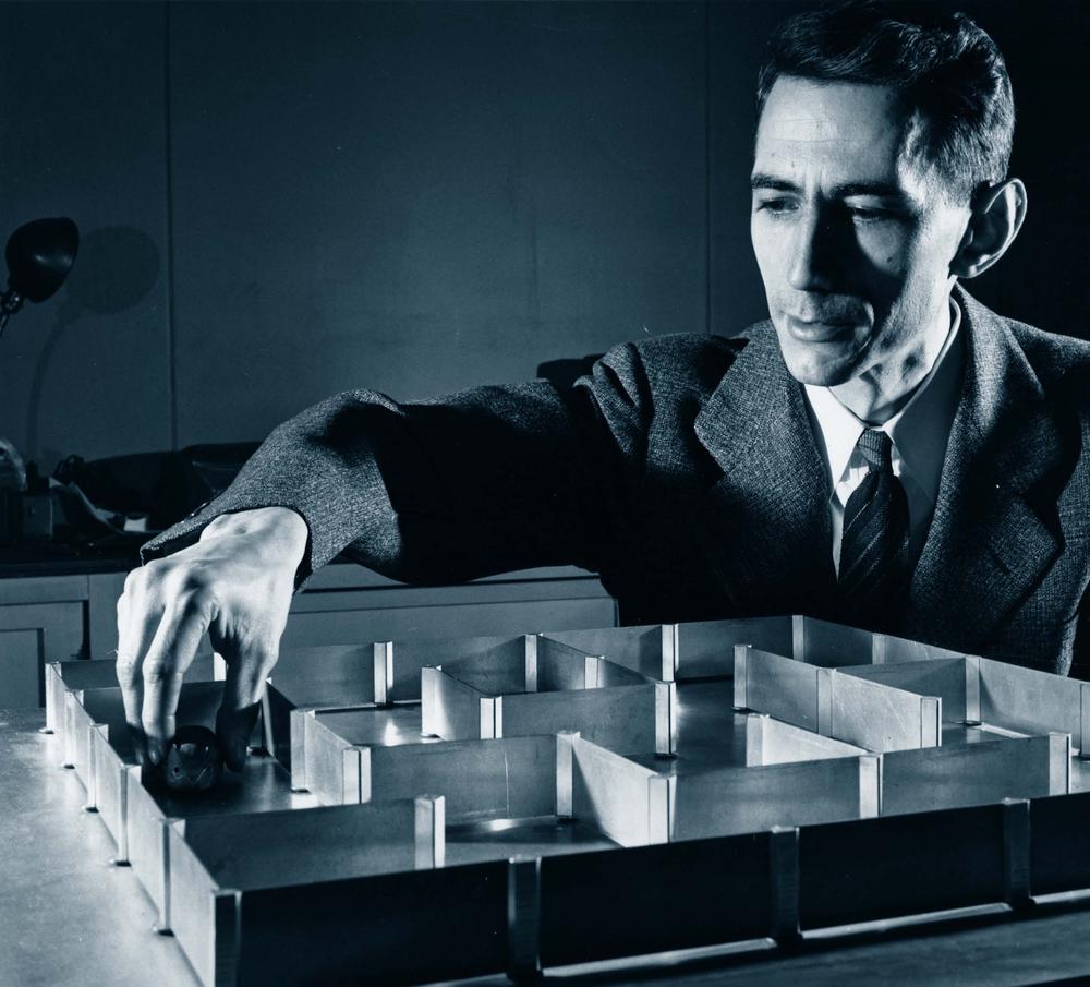 Information theory pioneer Claude Shannon pictured ca. 1950 with his mechanical mouse Theseus and its magnetic metal maze. Courtesy and copyright MIT Museum.