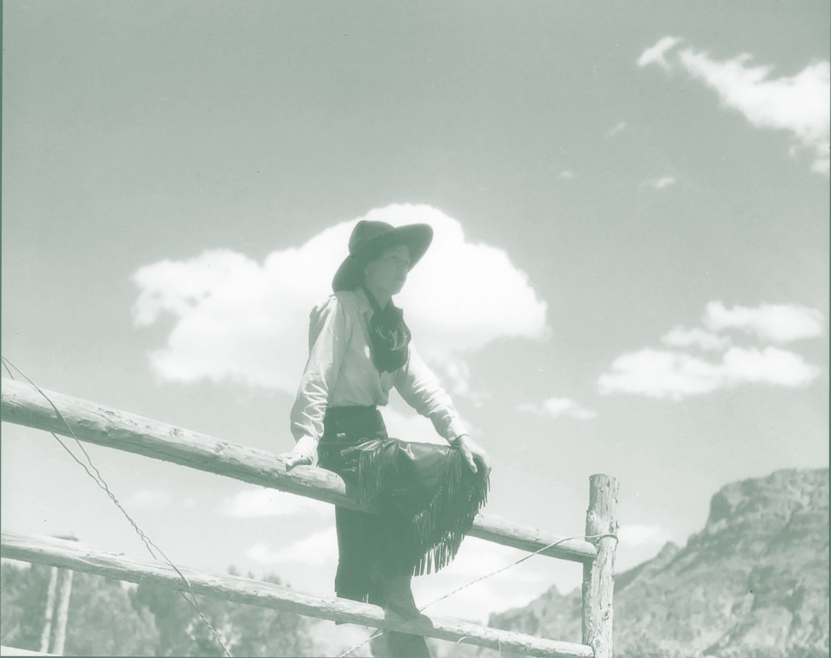 Photo of cowgirl on fence.