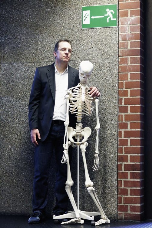 Tim Meyer, 47, mit einem Modell des menschlichen Skeletts in seinem Institut in Saarbrücken