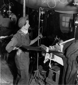 Capt. Sylvia Pavolvich, army nurse of the 8209th Mobile Surgical Hospital, US Eighth Army, administers whole blood to a wounded US X Corps soldier..tif