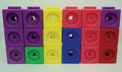 Photo of a series of 6 towers formed by stacks of snap cubes. Each stack is three cubes high.