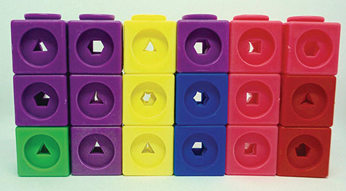 Photo of a series of 6 towers formed by stacks of snap cubes. Each stack is three cubes high.