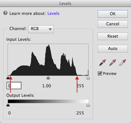 To use the Levels input sliders, simply drag the left and right sliders from the ends of the track until they’re under the outer edges of the color data in the graph.The red arrows in this figure show where you’d position the left and right sliders for this particular photo, respectively. If there’s empty space on the end of the graph (as there is here), just move the slider until it’s under the first mound of data.