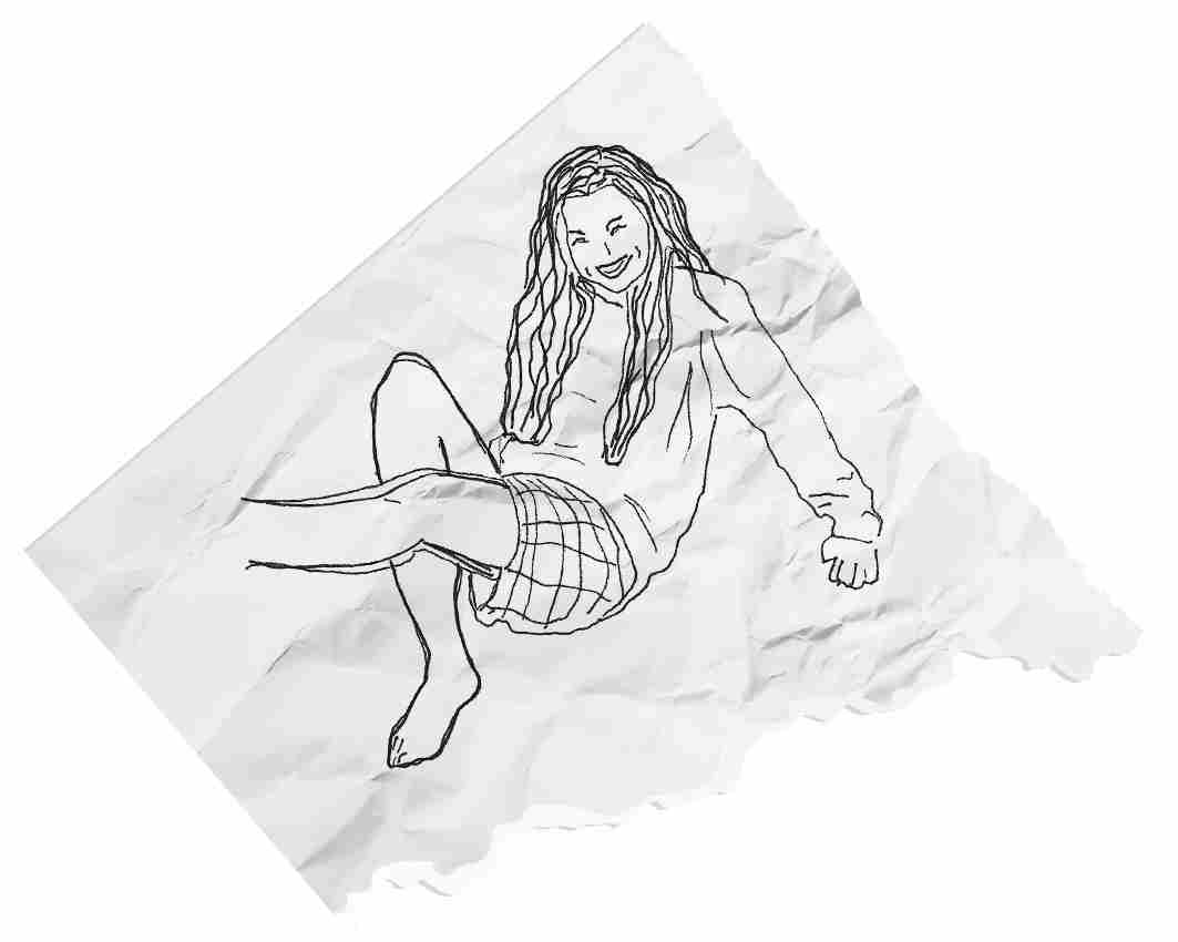 A drawing of a person on a wrinkled torn piece of paper. They sit with one knee propped up and one leg kicking up, their palms pressed on the ground behind them to hold themselves up. They have long dark hair that falls to their waist. They wear a plain long-sleeved top and shorts with a grid pattern. They smile with scrunched eyes.